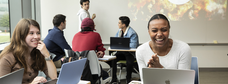 Students in a classroom engaged in listening and laughter.
